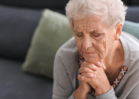 Elderly woman sitting on a couch worried