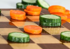 Chessboard with carrots and cucumber