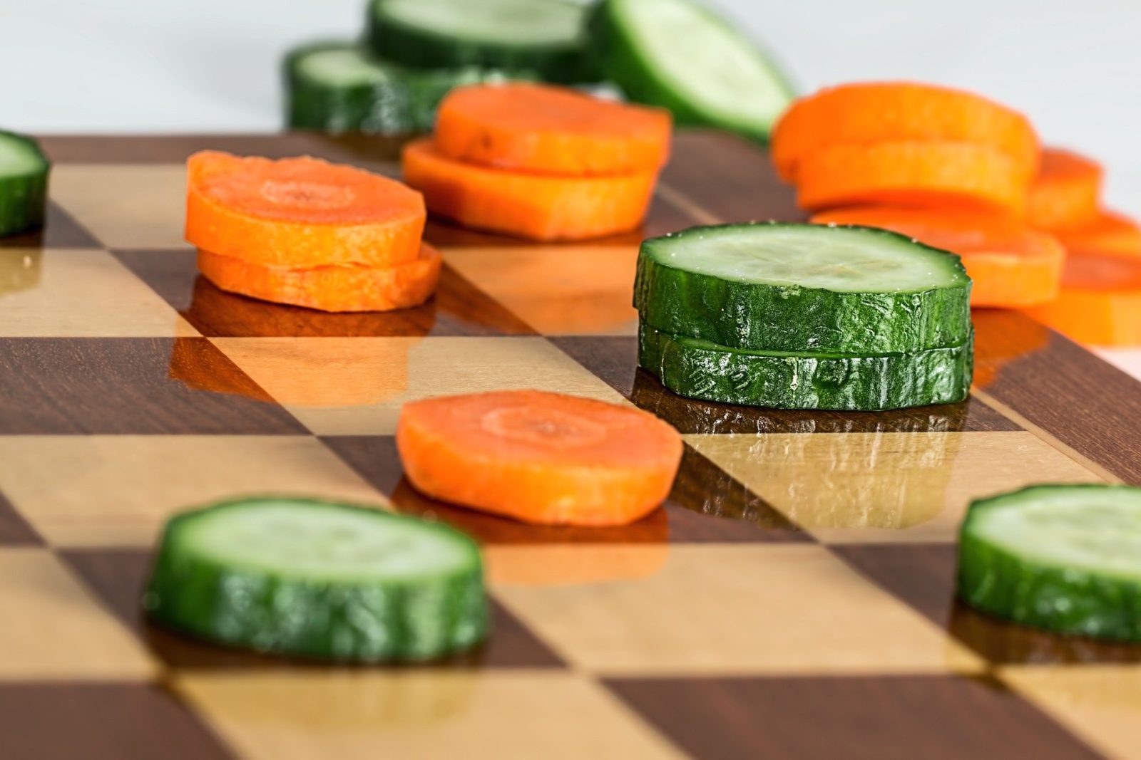 Chessboard with carrots and cucumber