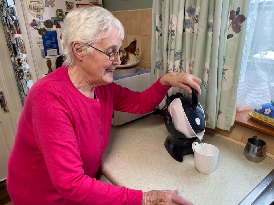Elderly woman using the tilt to pour action of the Uccello Kettle
