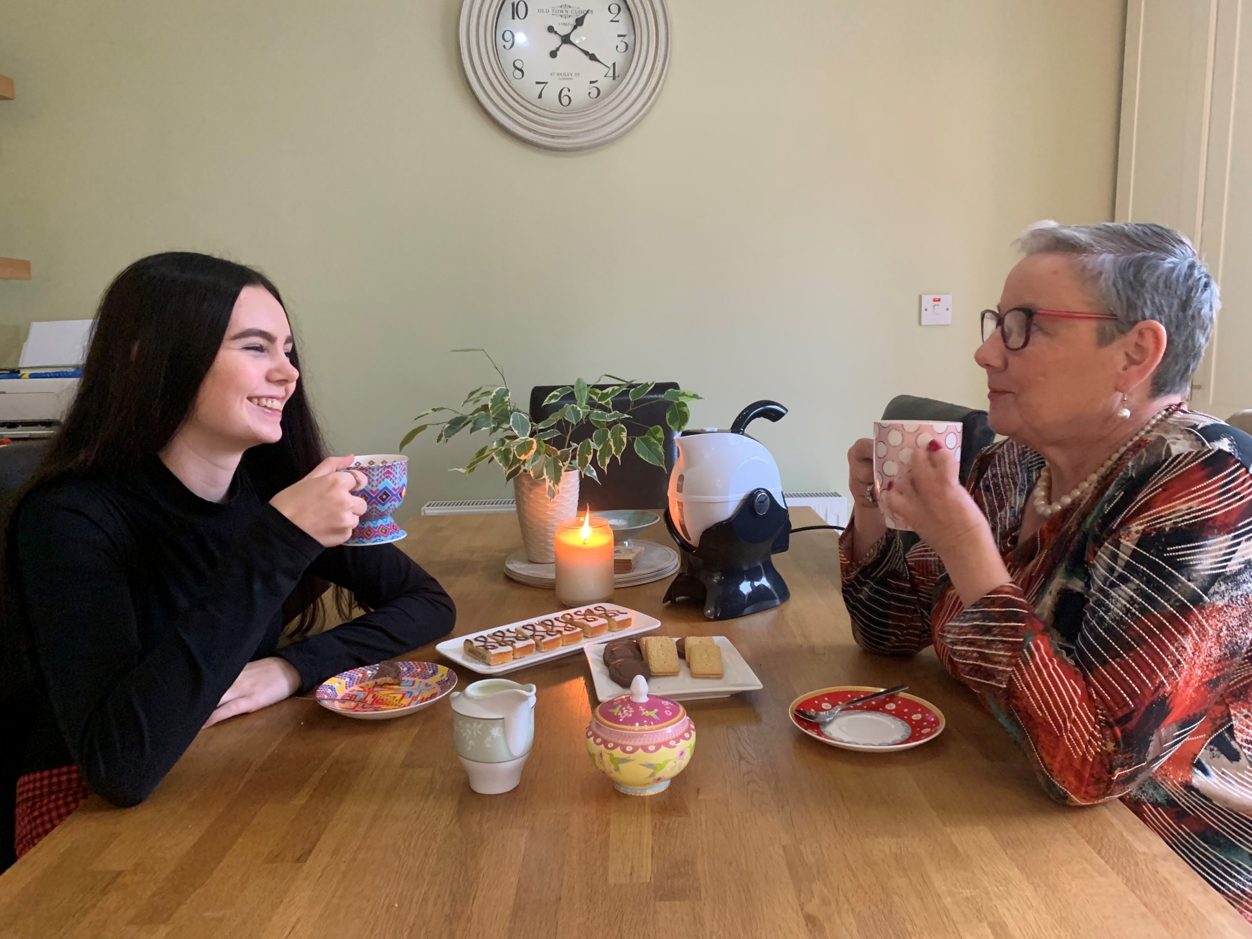 Granddaughter and grandmother sharing a conversation over a cup of tea